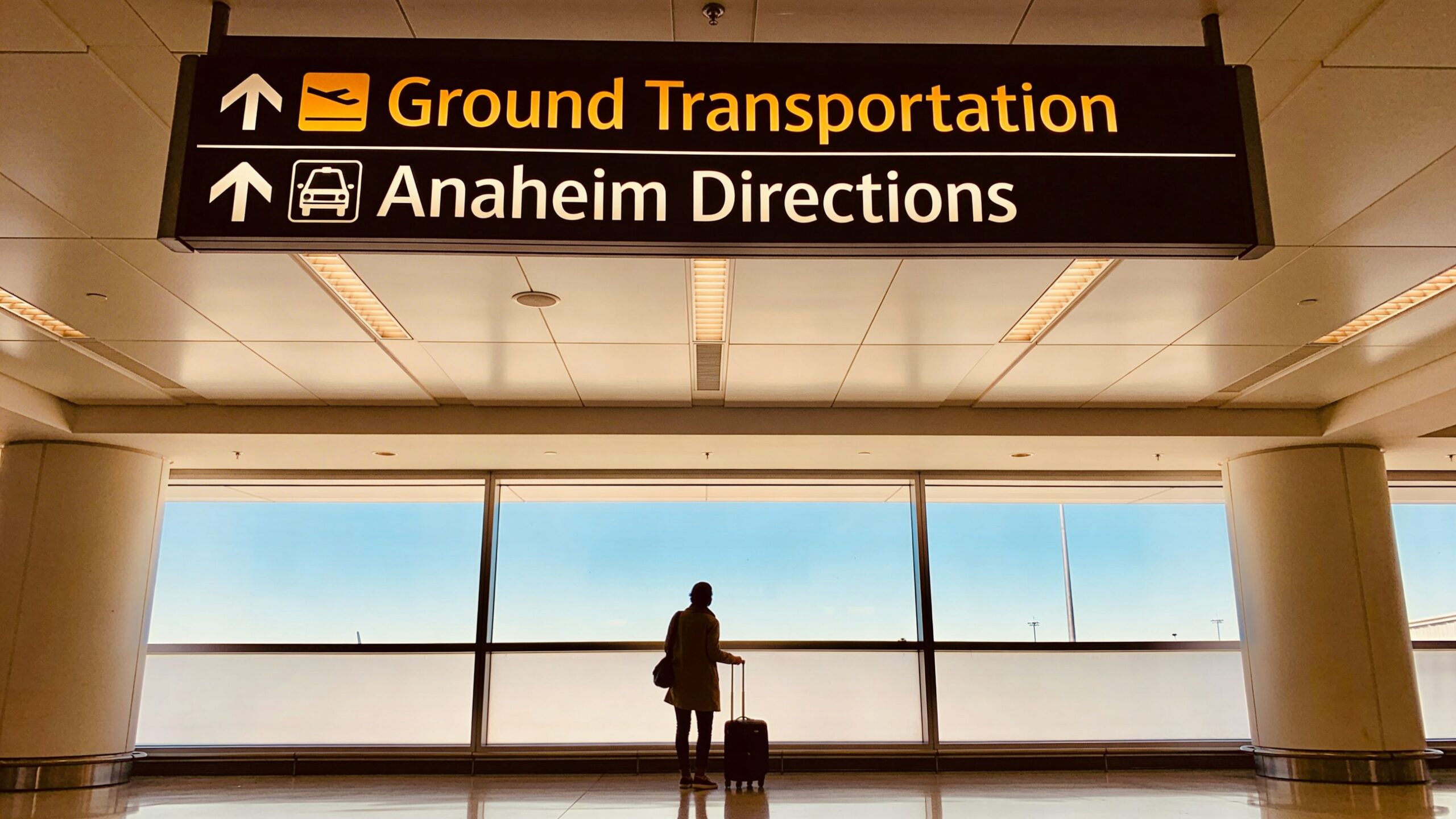 How far is anaheim from lax airport: How Far is Anaheim From 1 Rides On Time A traveler with luggage stands under an airport directional sign for Ground Transportation and Anaheim Directions.